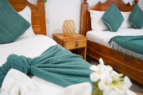 a bedroom with two beds with green and white towels at Chair Riverside in Luang Prabang