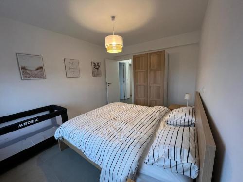 a bedroom with a bed in a room with a piano at En Bord de Mer in Middelkerke
