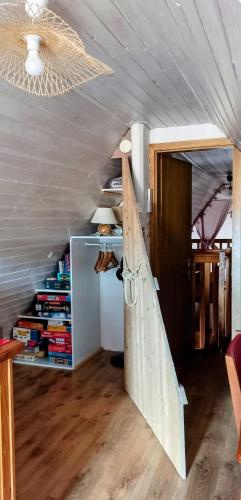 an attic room with a wooden door and a book shelf at Un balcon sur les toits in Beblenheim