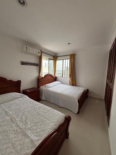 une chambre avec deux lits et une fenêtre dans l'établissement Apartamento con vista al mar, à Carthagène des Indes