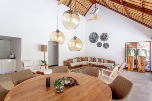 a living room with a wooden table and chairs at Balidroomvilla Sanur - Full Serviced - Beachside in Sanur