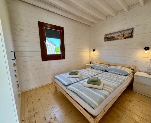 a bedroom with a bed with two towels on it at KOPUVA in Nidden