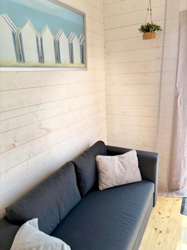 a blue couch with a pillow on it in a room at KOPUVA in Nidden
