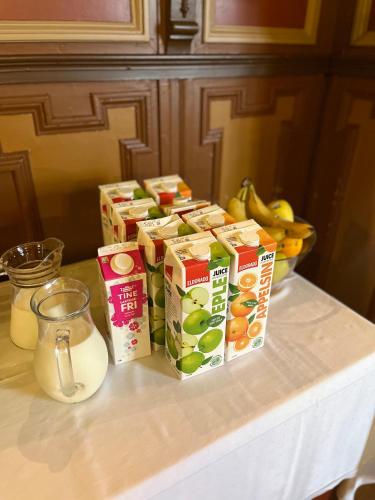 Un mostrador con tres cajas de leche y un bol de fruta. en Hald Bed and Breakfast, en Mandal