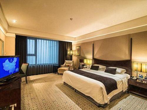 Ένα ή περισσότερα κρεβάτια σε δωμάτιο στο Grand New Century Hotel Binhai Tianjin