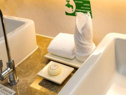 a bathroom with towels on a counter next to a sink at Northwest Petroleum Hotel in Ürümqi