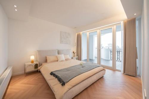a bedroom with a large bed and a large window at Pure Home-Near the Bund enjoys the beautiful scenery of the Bund 3-bedhome close to Yuyuan Garden Huaihai Road and Nanjing Road Pedestrian Street in Shanghai