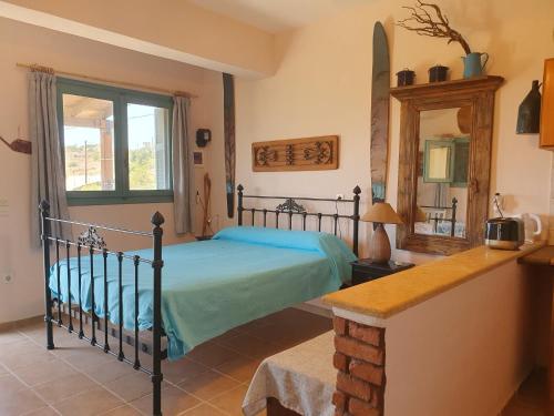 una camera da letto con un letto e uno specchio di Managros Rooms - Studio Thea a Chorí