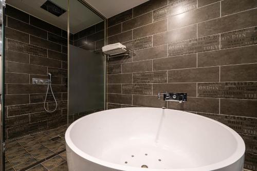 a bathroom with a bath tub and a shower at Busan Hound Hotel Daeyeon in Busan