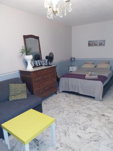 une chambre avec un lit, un canapé et un miroir dans l'établissement Studio Californie, à Nice