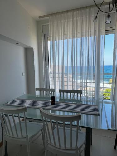 a dining room with a table and chairs and a large window at Sisi Blue Seafront Apt in Sissi