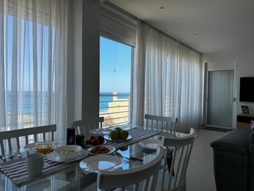 a dining room with a table and a view of the ocean at Sisi Blue Seafront Apt in Sissi