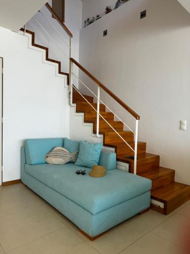a blue couch in a living room with a staircase at Sisi Blue Seafront Apt in Sissi