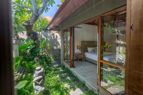 a room with a bed and a garden at Balidroomvilla Sanur - Full Serviced - Beachside in Sanur