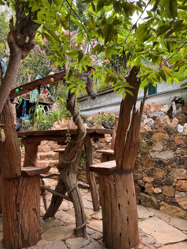 a wooden bench sitting next to a stone wall at Wild Heart Glamping in Ella