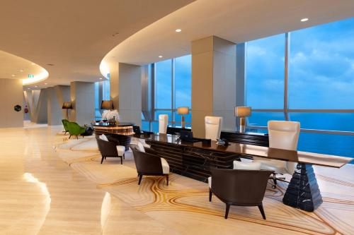 a hotel lobby with a dining table and chairs at Nuwa Sri Lanka at City of Dreams in Colombo
