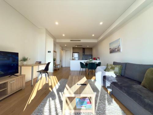 a living room with a couch and a table at Chic 1BR Condo next to Croydon Station in Sydney