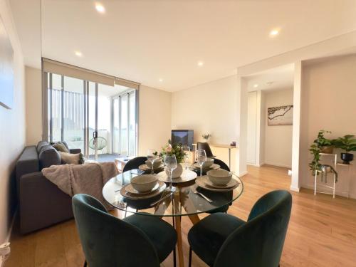 a living room with a glass table and chairs at Chic 1BR Condo next to Croydon Station in Sydney