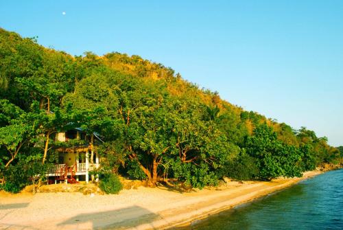 a house on a beach next to the water at Alam Indah Busuanga Beach and Villas in Busuanga