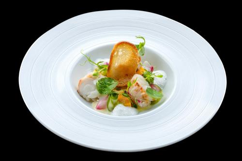 a white plate with a dish of food on it at Nuwa Sri Lanka at City of Dreams in Colombo