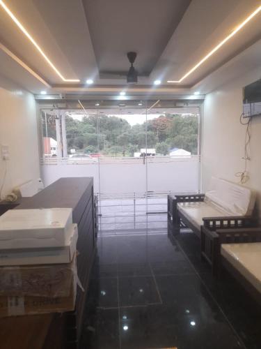 a room with two beds and a large window at Ideal Residency in Gulbarga