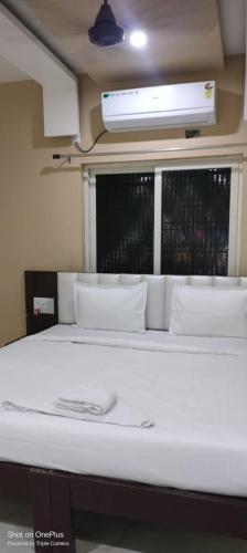 a white bed in a room with a window at Ideal Residency in Gulbarga