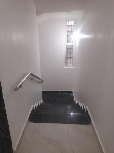a stairway with a window in a white room at Ideal Residency in Gulbarga