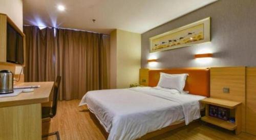 a hotel room with a bed and a desk at 7 Days Premium Zhuhai Gongbei Light Railway Branch in Zhuhai