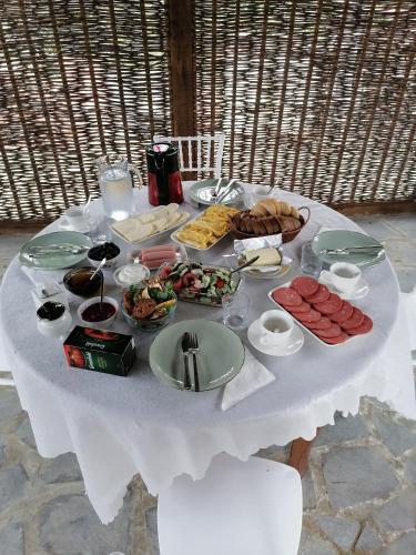 a white table topped with food and plates of food at Villa Obcha - Whispering Vines Guesthouse in Bagdatʼi