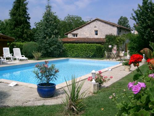 - une piscine dans une cour agrémentée de chaises et de fleurs dans l'établissement Villa Tournesol, à Bourdeilles