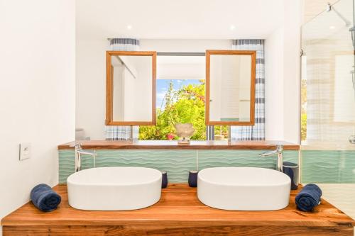two white tubs in a bathroom with a window at Bluepearl, Sileview Residence in Rivière Noire