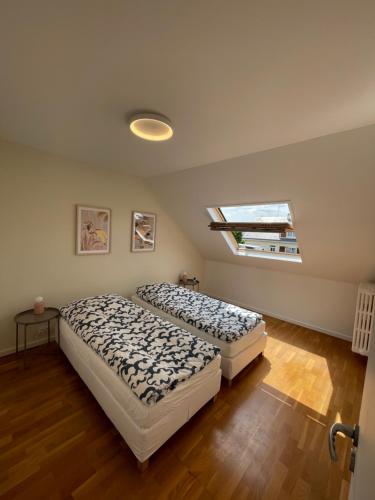 two beds in a bedroom with a skylight at Maison Cosy à Chartres in Chartres