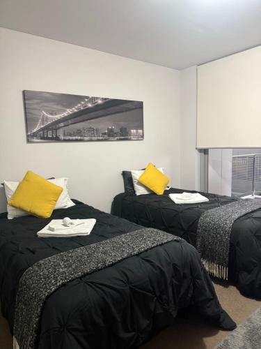 a room with two beds with yellow pillows at Cozy Private Room With Bathroom Right In Wollongong in Wollongong