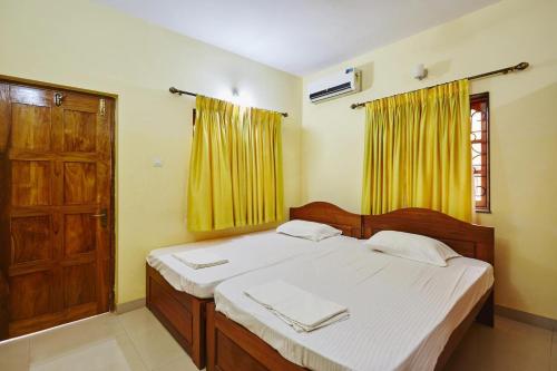 1 dormitorio con 1 cama y puerta de madera en Saikunj Holiday Homes en Candolim