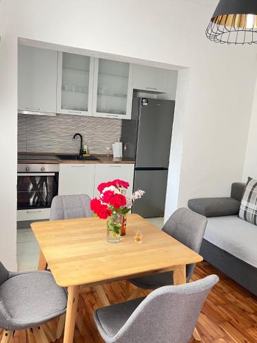 a kitchen with a wooden table with a vase of flowers at Apartman ANA in Vrlika