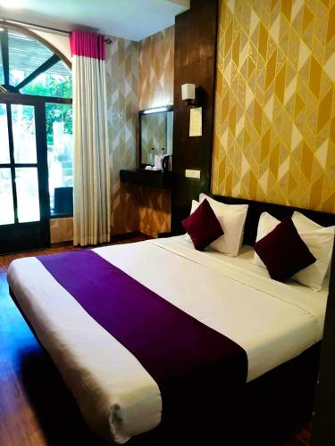 a bedroom with a large bed in a room at Ovitiyas Bandarawela in Bandarawela