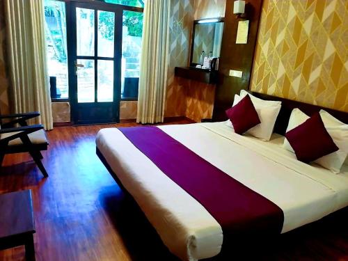 a bedroom with a large bed with a purple blanket at Ovitiyas Bandarawela in Bandarawela
