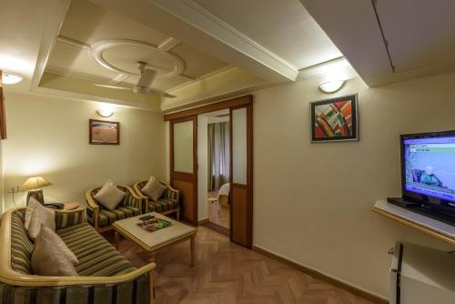 a living room with a couch and a flat screen tv at Comfort Inn President Near Ahmedabad Junction Station in Ahmedabad