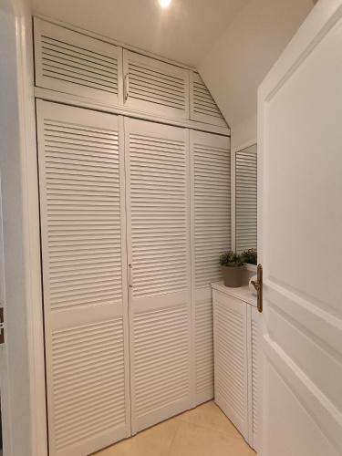 a closet with white closet doors in a room at Le Charme des Bastides in Castelnau-de-Montmiral