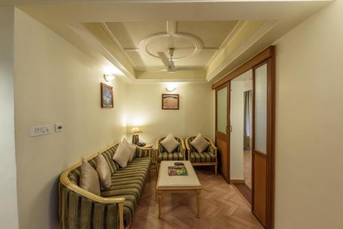 a living room with a couch and a table at Comfort Inn President Near Ahmedabad Junction Station in Ahmedabad
