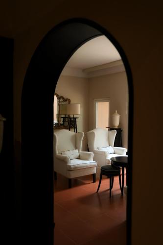 an archway in a living room with white chairs and a table at Santa Maria Foris in Ravenna