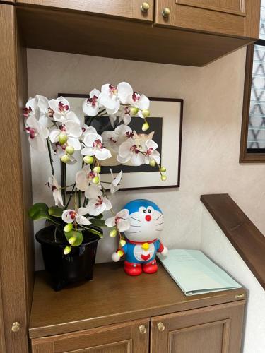 una pianta su un mobile accanto a un animale di peluche e un vaso di TSURUNOYA The only private lodging in Tokyo Japanese Tatami style 8 minutes walk from station free Parking new open Asakusa Akihabara Tokyo sky tree Disneyland nearby 110m2 a Tokyo