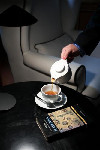 a person pouring coffee into a cup on a table at Santa Maria Foris in Ravenna