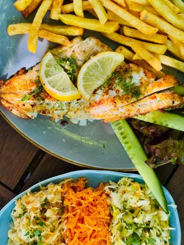 a plate of food with fish and rice and fries at Folwark Wierzchy in Wierzchy