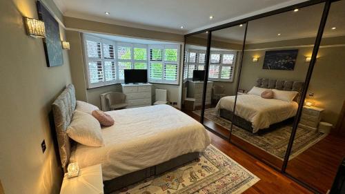 伦敦Stunning double bedroom Greenwich London with private bathroom的有两张床和一面镜子的卧室