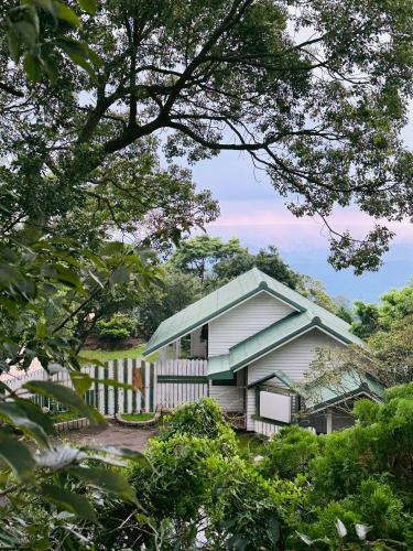 a house with a green roof and a fence at Chill hill cottage in Taiping