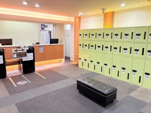 a locker room with green lockers and a bench at Hotel Premium Green Plus in Sendai