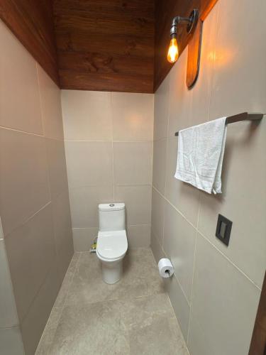 a bathroom with a toilet and a towel on the wall at Casa Campestre Los Nevados Patio Bonito in Estación El Salto