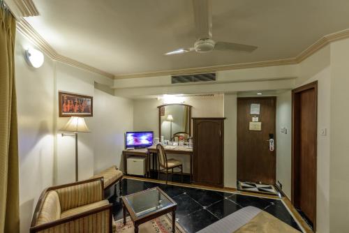 a hotel room with a reception desk and a living room at Comfort Inn President Near Ahmedabad Junction Station in Ahmedabad