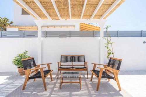 two chairs and a table on a patio at Koula's Aegina in Perdhika